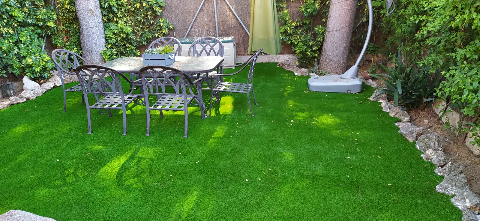 Vista general de zona ajardinada con césped artificial para uso familiar.