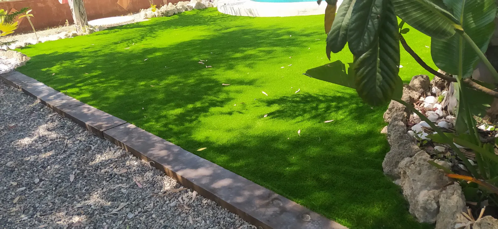 Ejemplo de jardín decorativo con césped artificial de alta densidad.